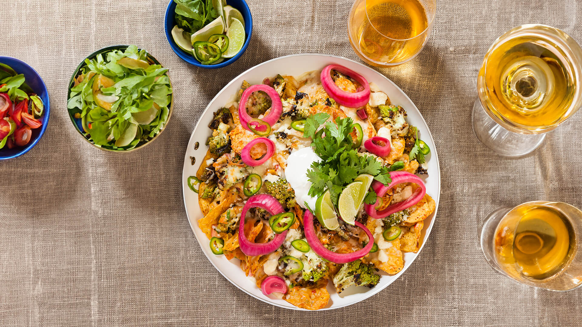 Nachos on a serving plate with white wine.